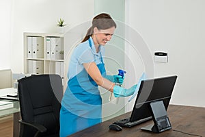 Female Janitor Cleaning Desk