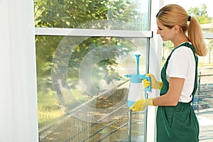 Female janitor cleaning window