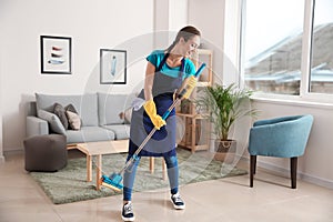 Female janitor having fun while cleaning flat