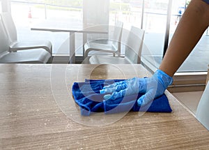 Female  Janitor`s Hand Cleaning Wooden Desk With Soft Cloth