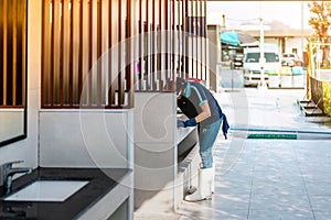 Female janitor using fabric and a detergent cleaning sink and tap