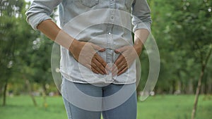 Female in jeans feeling strong lower abdominal pain, menstruation, health care