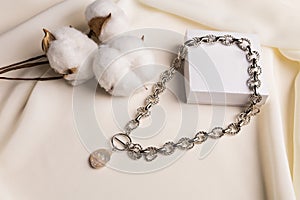 Female Jewelry. Vintage bijouterie jewelry. Handmade silver necklace with pearl on beige fabric background with gift box