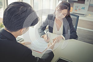 Female job candidate signing work contract with HR officer after a successful job interview