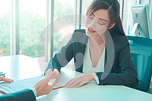 Female job canidate signing work contract with HR officer after a sucessful job interview