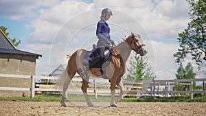 Female Jockey Wearing Safety Helmet Riding On A Beautiful Palomino Horse