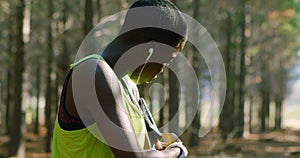 Female jogger adjusting arm band in the forest 4k