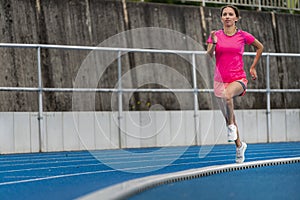 Female jogger on a blue track