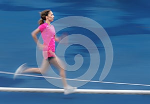 Female jogger on a blue track