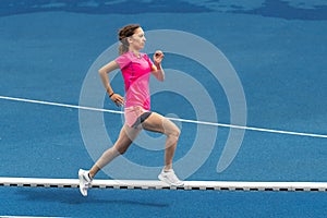 Female jogger on a blue track