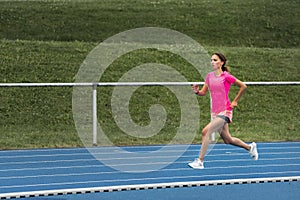 Female jogger on a blue track