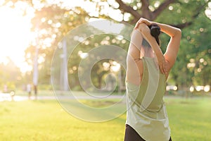 Female jogger. Fit young Asian woman with green sportswear stretching muscle in park before running and enjoying a healthy outdoor