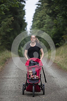 Una donna chi corre per la salute spingendo suo un bambino un bambino vagabondo mentre sul correre 