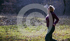 Female jogger running at cold morning rising breath vapour photo