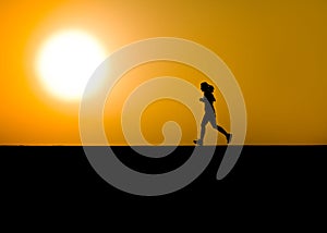 Female jogger in silhouette with large sun