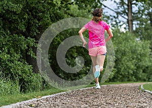 Female jogger on a track between trees