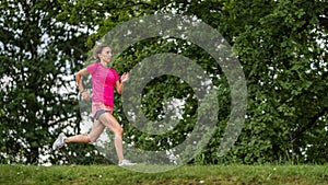 Female jogger on a track between trees