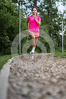 Female jogger on a track between trees