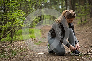 Female jogger tying sporty shoes