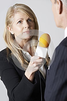 Female Journalist With Microphone Interviewing Businessman