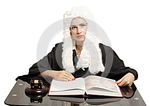 Female judge wearing a wig and black mantle with judge gavel and