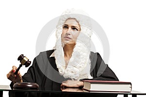 Female judge wearing a wig and black mantle with judge gavel and