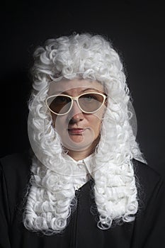 Female judge wearing a wig and black mantle with sunglasses