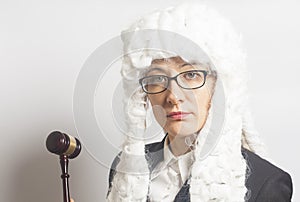 Female judge wearing wig and mantle with eyeglasses holding ju