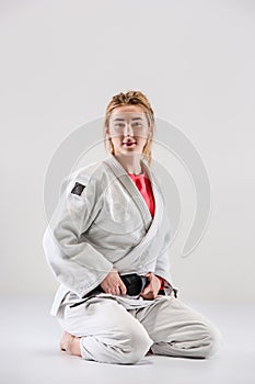 The female judokas fighter posing on gray