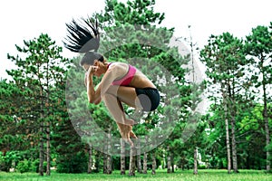 Female jumping outside in the park.