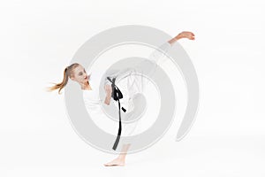 female karate fighter with black belt performing kick