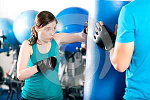 Female kick boxer with trainer in sparring