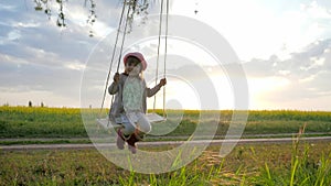 Female kid swaying, happy little child have fun sway spin on swing, nature sunset, forest park, children on swing