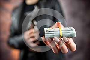 female killer hold gun pistol and stack of dollar