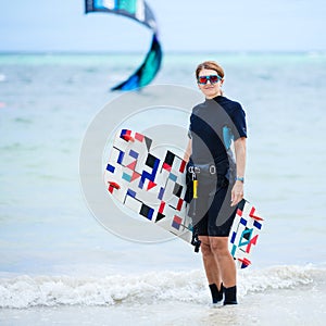 Female kiteboarder carrying her board