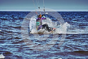 A female kiter slides on the surface of the water.