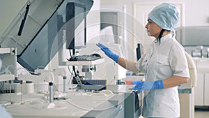 Female lab expert is managing Automatic Pharmaceutical Equipment.