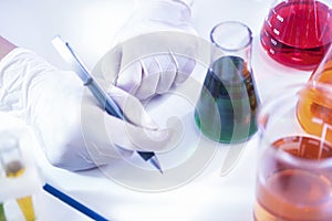 Female Laboratory Worker Dealing With Flasks Containing Liquid Chemicals