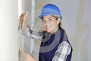 female labourer removing wallpaper in renovation property photo