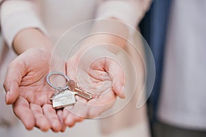 Female landlord gives keys symbolizing new home purchase. Represents successful