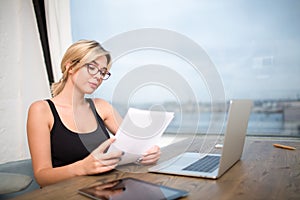 Female lawyer in glasses exploring summary or contract