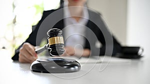 Female lawyer with a judge gavel on the desk. Selective focus on judge gavel