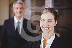 Female lawyer smiling while male colleague in background