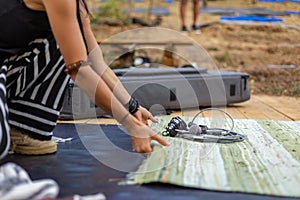 Female laying down a blanket on a wooden floor with reportage equipment on top