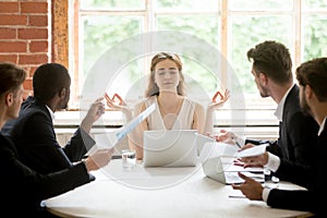 Female leader meditating ignoring angry coworkers