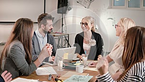 Female leader reported good news, everyone is happy, high-fiving each other business team in a modern startup office.