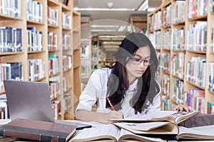 Female learner doing assignment in library photo