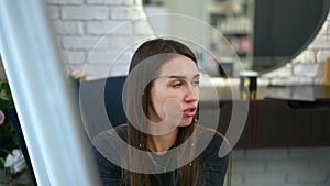 A female lecturer, standing near a presentation board, conducts training on trichology in a modern beauty salon. Close