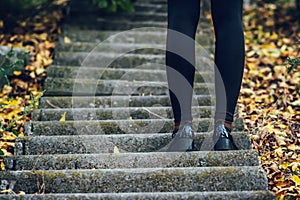 Female legs in black tights and shoes on the steps. autumn.