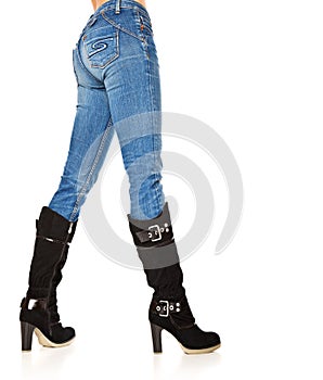 Female legs in a blue jeans and high boots
